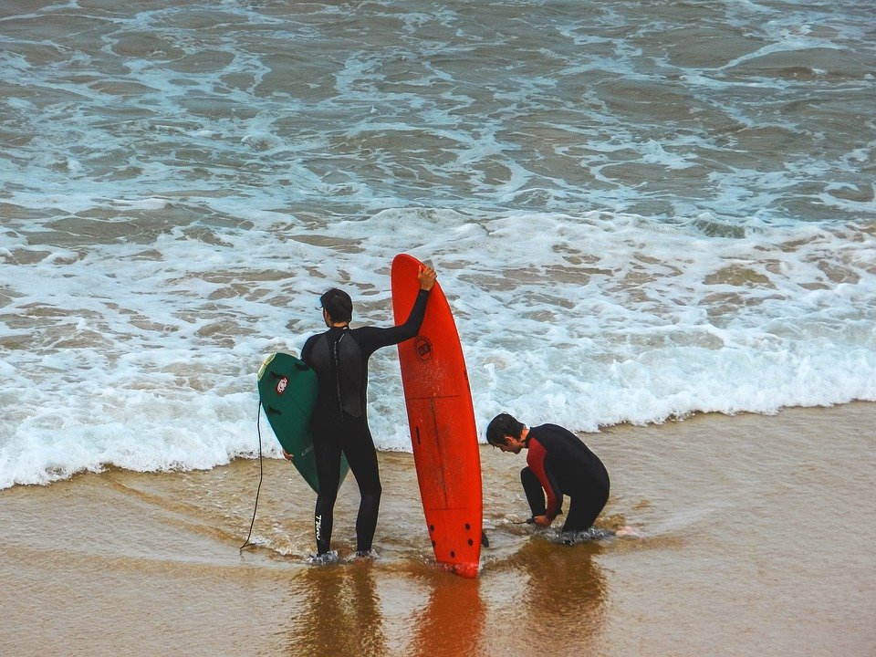 Two men getting ready to surf.